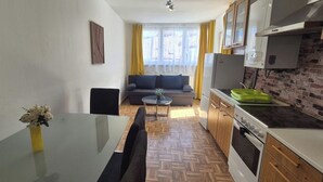 A compact living space with a kitchenette, a dining area, and a sofa.