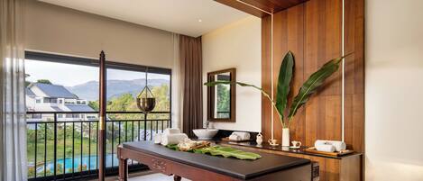 A modern room with a wooden ceiling, a dining table with a bench, a view of a swimming pool, and a large plant.