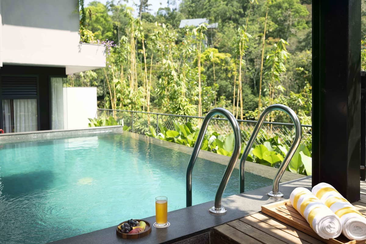 Un espace aménagé au bord de la piscine, avec une boisson, des fruits et des serviettes à disposition.
