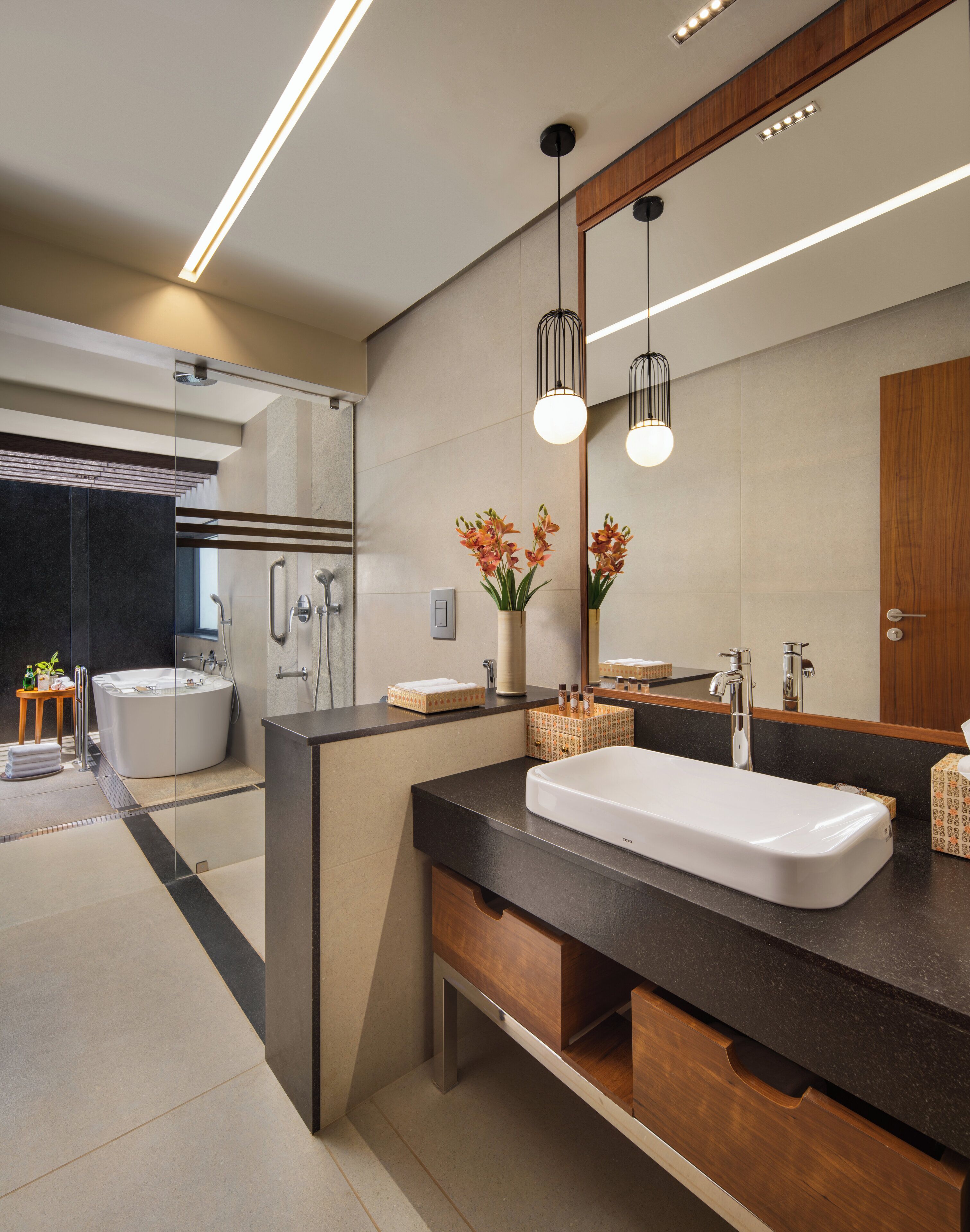 Un baño moderno con un lavabo grande, espejo e inodoro con ducha integrado.