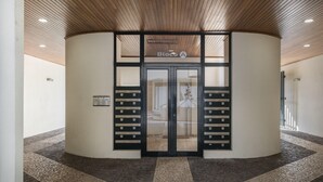 Entrada de un edificio con diseño circular, techo de madera y un letrero que dice 'Bloco A'.