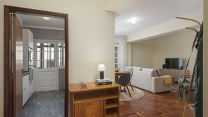 Una sala de estar moderna con un escritorio de madera, un sofá y una televisión.