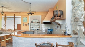 Una cocina rústica con pared de piedra, encimera de madera y chimenea de ladrillo integrada.