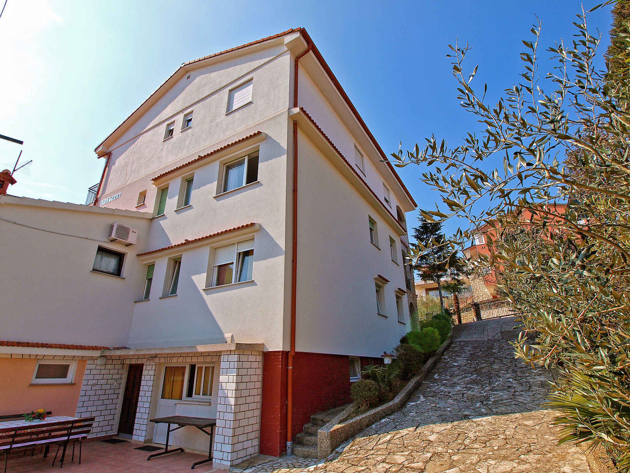 A two-story building with a tiled entrance and a stone staircase leading up to the entrance.