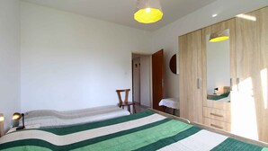 A bedroom with a bed, a wardrobe, a chair, and a desk. - Holiday apartment with air conditioning (Pula)