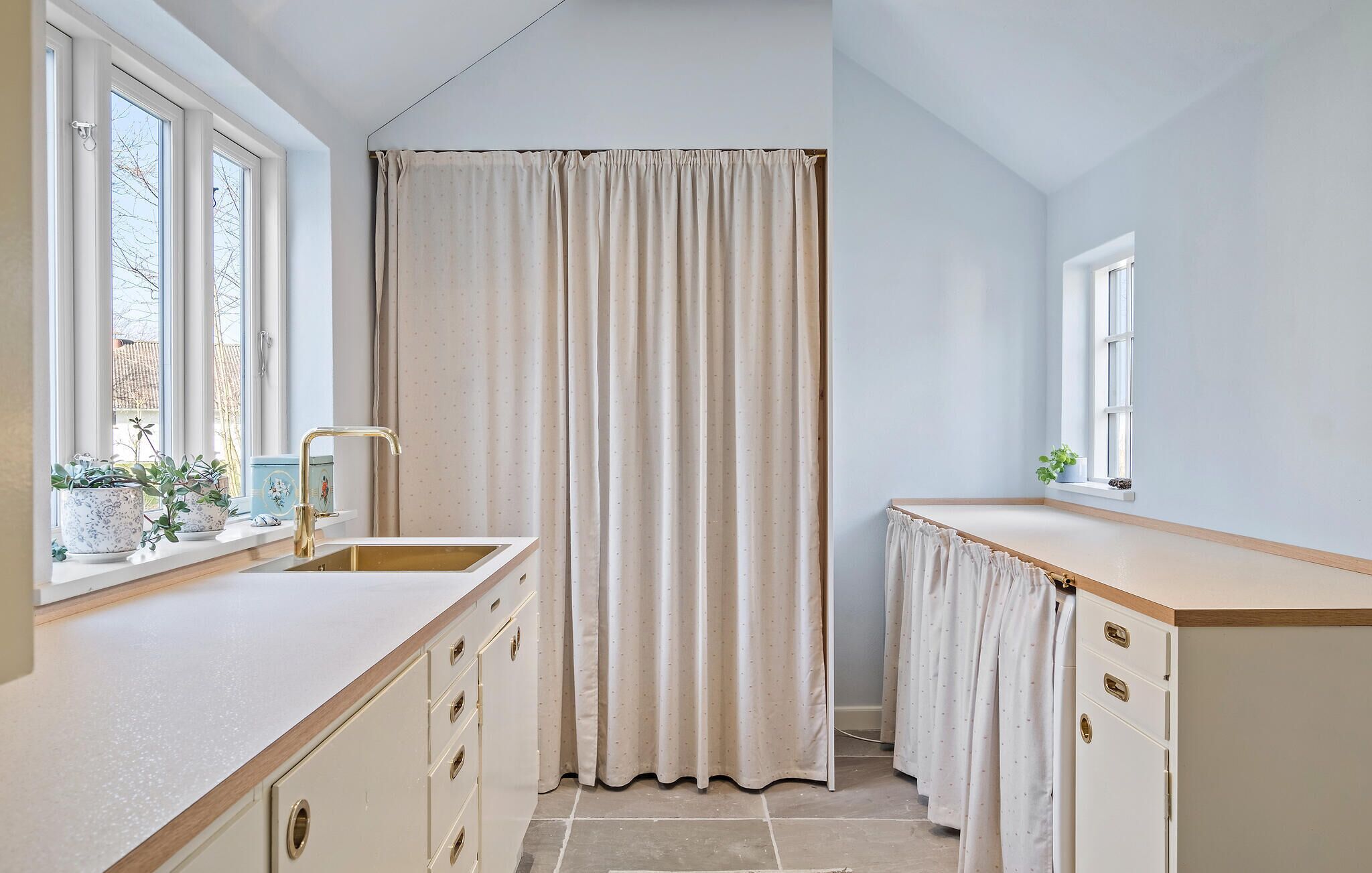 A narrow bathroom with a sink, a mirror, and a window.