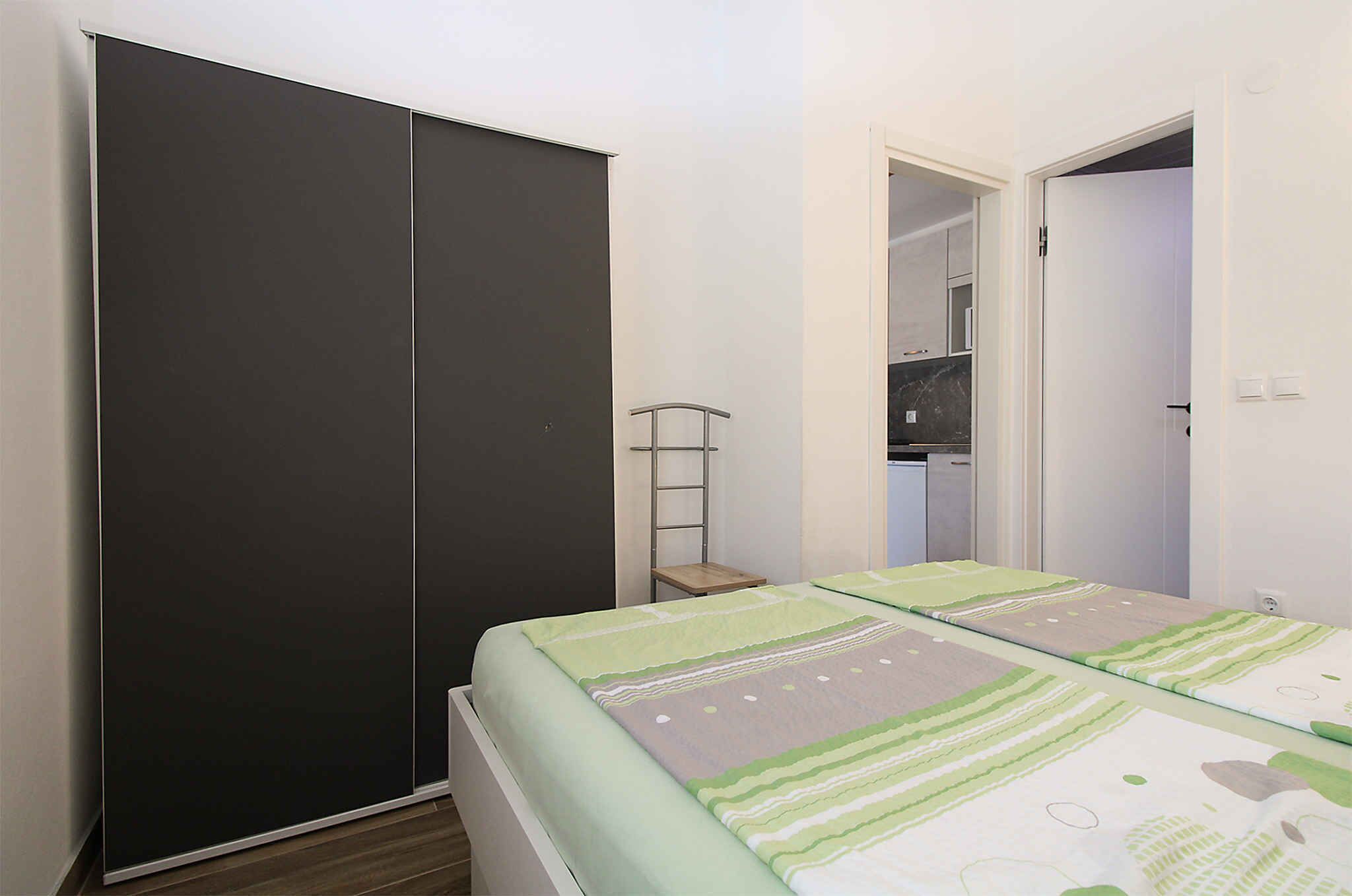 Ein Schlafzimmer mit einem Bett, einem Kleiderschrank und einem kleinen Tisch.