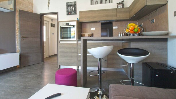 A modern kitchen with a bar area, a refrigerator, and a sink.