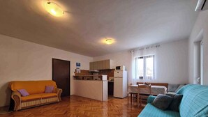 A compact living space with a kitchenette, two sofas, and a dining table. - Holiday flat with air conditioning (Valbandon)