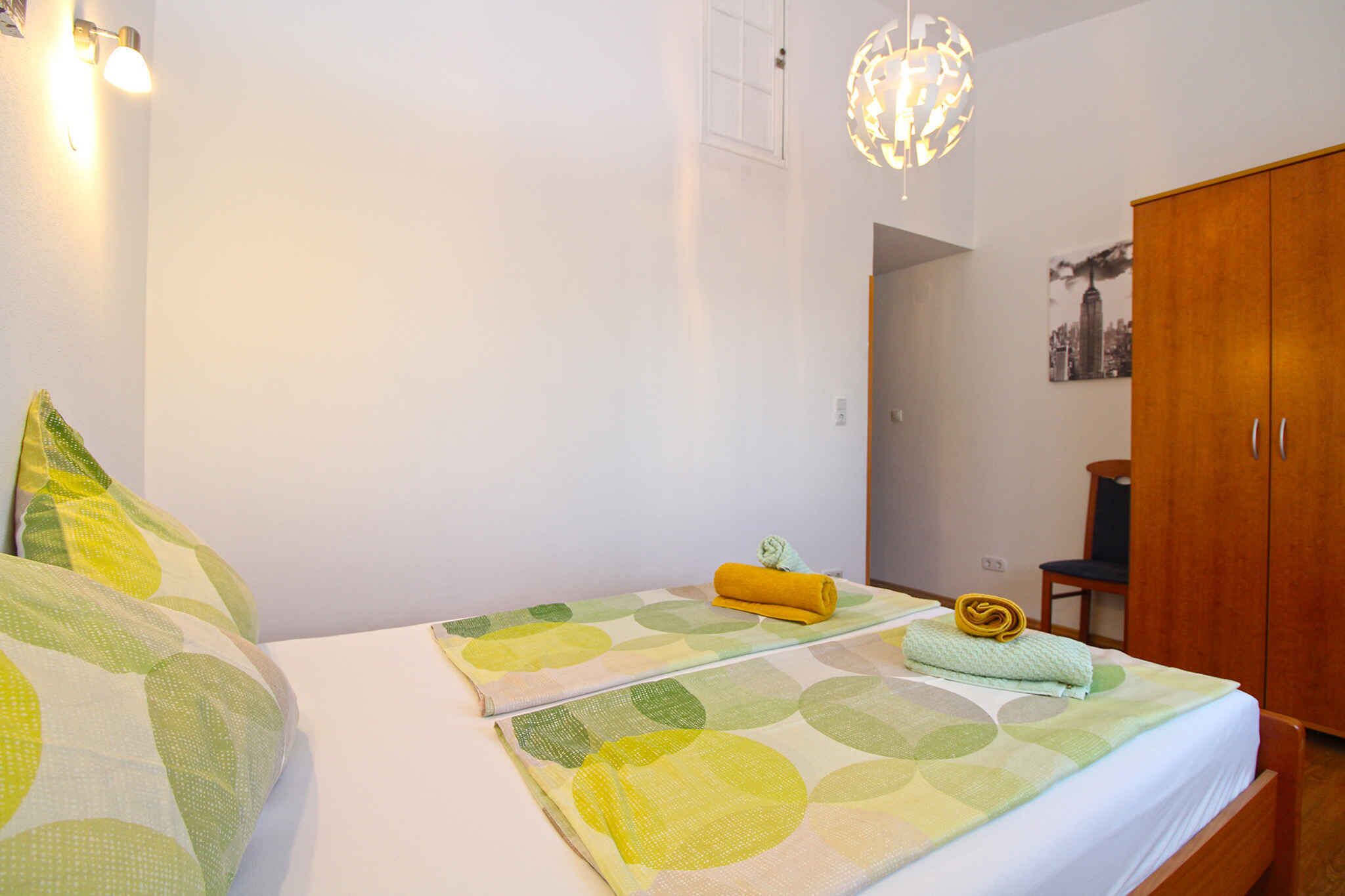 Una habitación de hotel con dos camas, un armario de madera y un cartel con una vista urbana en la pared.