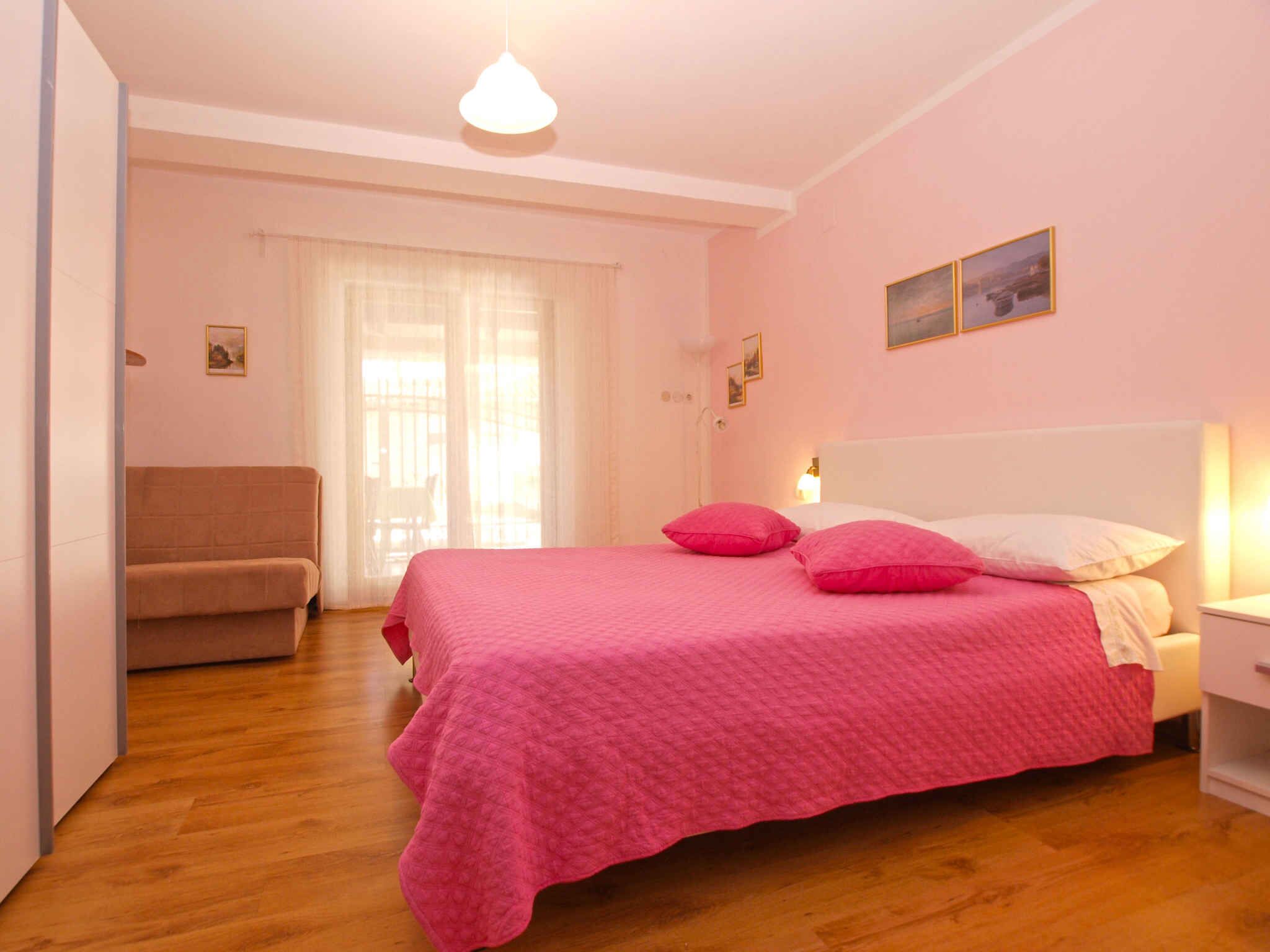 A bedroom with a bed, a chair, and a nightstand.