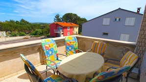 A patio with a round table and six chairs, each with colorful upholstery.