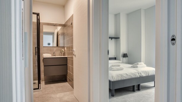Une salle de bain moderne avec une douche, un lavabo et un miroir.