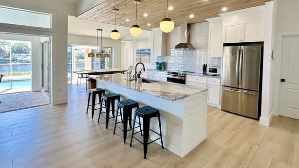 A spacious kitchen with a large island, modern appliances, and a view of a pool. - Punta Gorda Canal Waterfront I Pool, Kayaks, Bikes, Boat Dock (Punta Gorda)