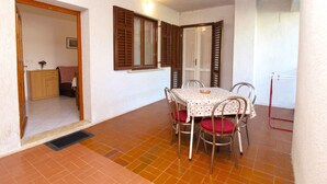 Un espace repas comprenant une table et des chaises, un buffet et une porte donnant sur une autre pièce.