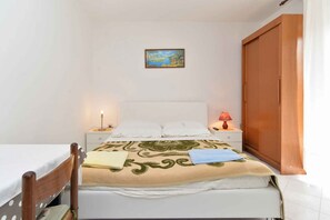 Cozy bedroom with a single bed, bedside tables, and a comfortable chair.