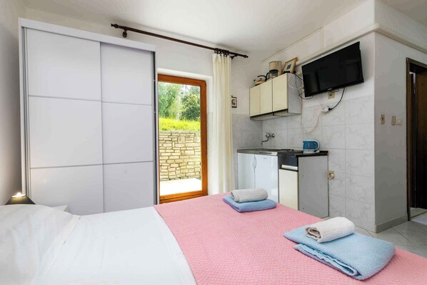 Une chambre à coucher avec un lit, une couvre-lit rose et deux serviettes.