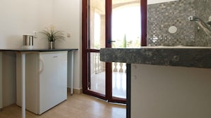 A compact kitchen with a refrigerator, a sink, and a window with a view of the outdoors. - Holiday apartment with balcony (Valbandon)