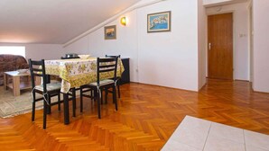 A dining area with a table and chairs, an air conditioning unit, and a door. - Holiday apartment with air conditioning (Štinjan)