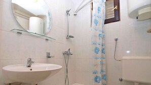 Une salle de bain équipée d’un lavabo, d’une baignoire, de toilettes et d’une douche.