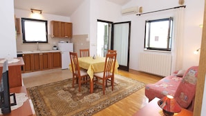 A compact living space with a dining area, kitchen, and a cozy seating area.