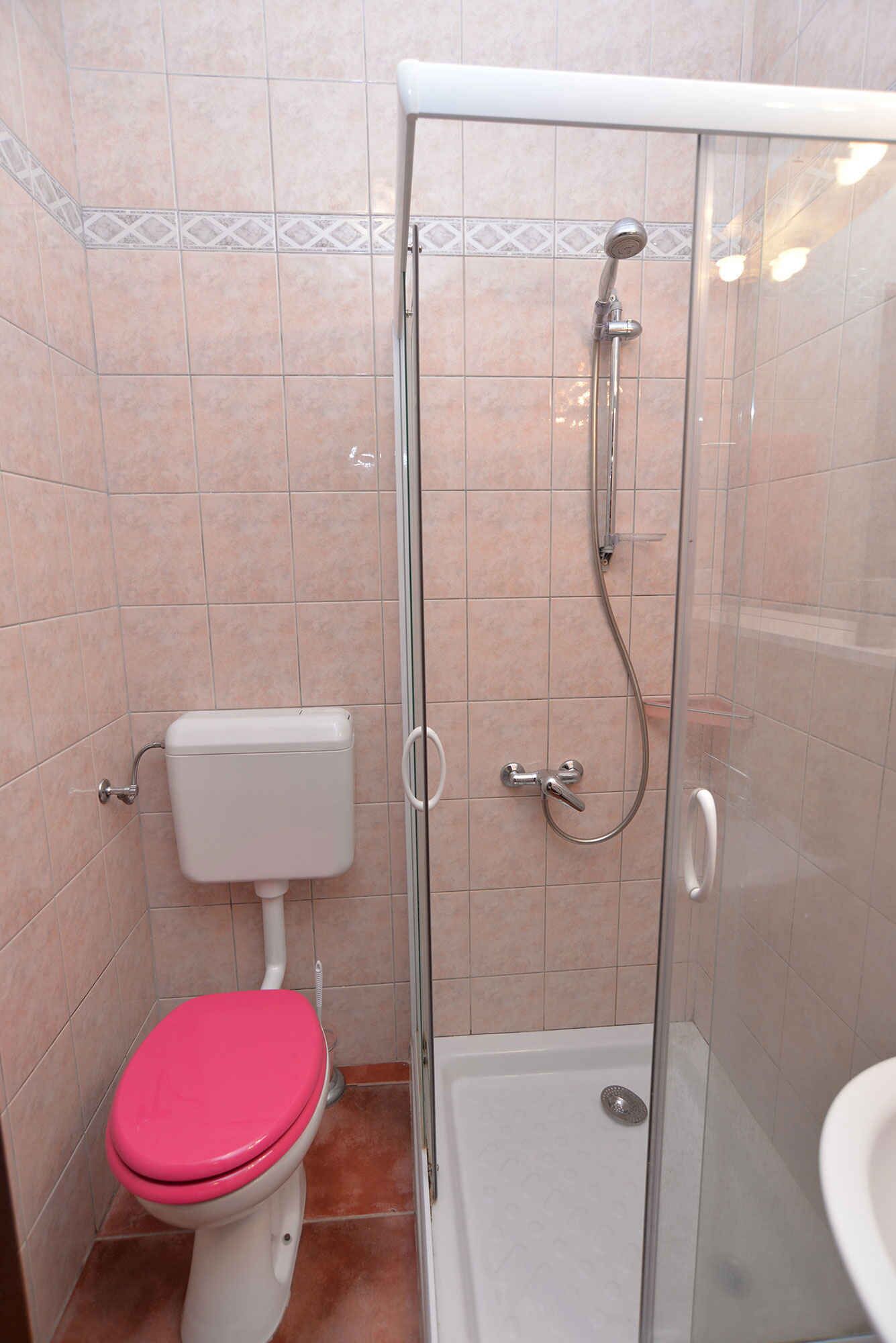 Ein Badezimmer mit Toilette, Duschkabine und Waschbecken.