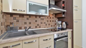A kitchen with a double sink, stainless steel appliances, and a tiled backsplash.