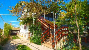A narrow pathway leading to a building with a staircase and a fence. - Holiday apartment with air conditioning and a view of the sea (Štinjan)
