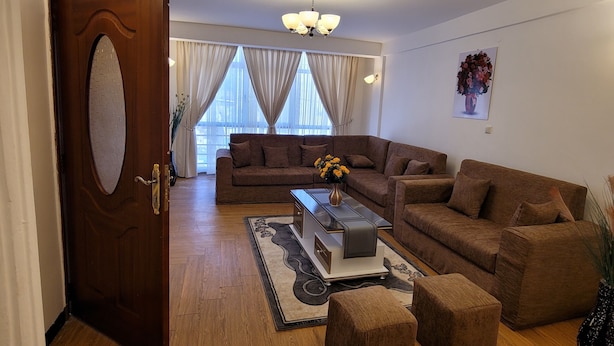A modern living room with a sectional sofa, a coffee table, and a chandelier. - Highly rated, clean, and spacious guest house in the Bethel area! Great discount (Kolfe Keranio)