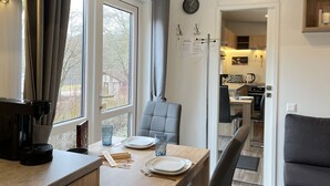 Una cucina moderna con zona pranzo, un orologio al muro e vista sull'esterno.