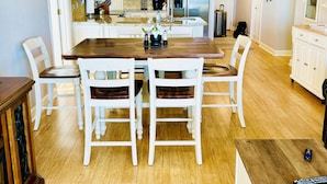 A modern kitchen with white cabinets, a central island, and a ceiling fan. - Two of the three bedrooms have ocean front balconies! (North Myrtle Beach)