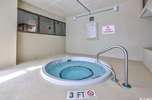 Una pequeña piscina interior con un indicador de profundidad de 3 pies, un cartel de prohibido bucear y un cartel que indica que no se permiten recipientes de vidrio.