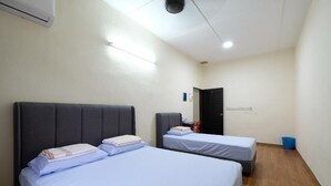A room with two beds, a door, and a blue trash bin. - CLP Home near Sri Muniswarar Temple 2 (Perai)