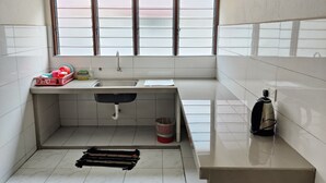 A small, clean kitchen with a window, a sink, and a countertop. - CLP Home near Sri Muniswarar Temple 2 (Perai)