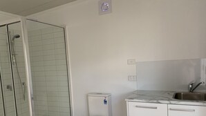 A bathroom with a glass-enclosed shower, a toilet, and a sink with a marble countertop. - Toorak pristine central area pool, minutes to transport, shops, services. (Melbourne)