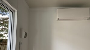 A room with white walls, a window, and an air conditioning unit. - Toorak pristine central area pool, minutes to transport, shops, services. (Melbourne)