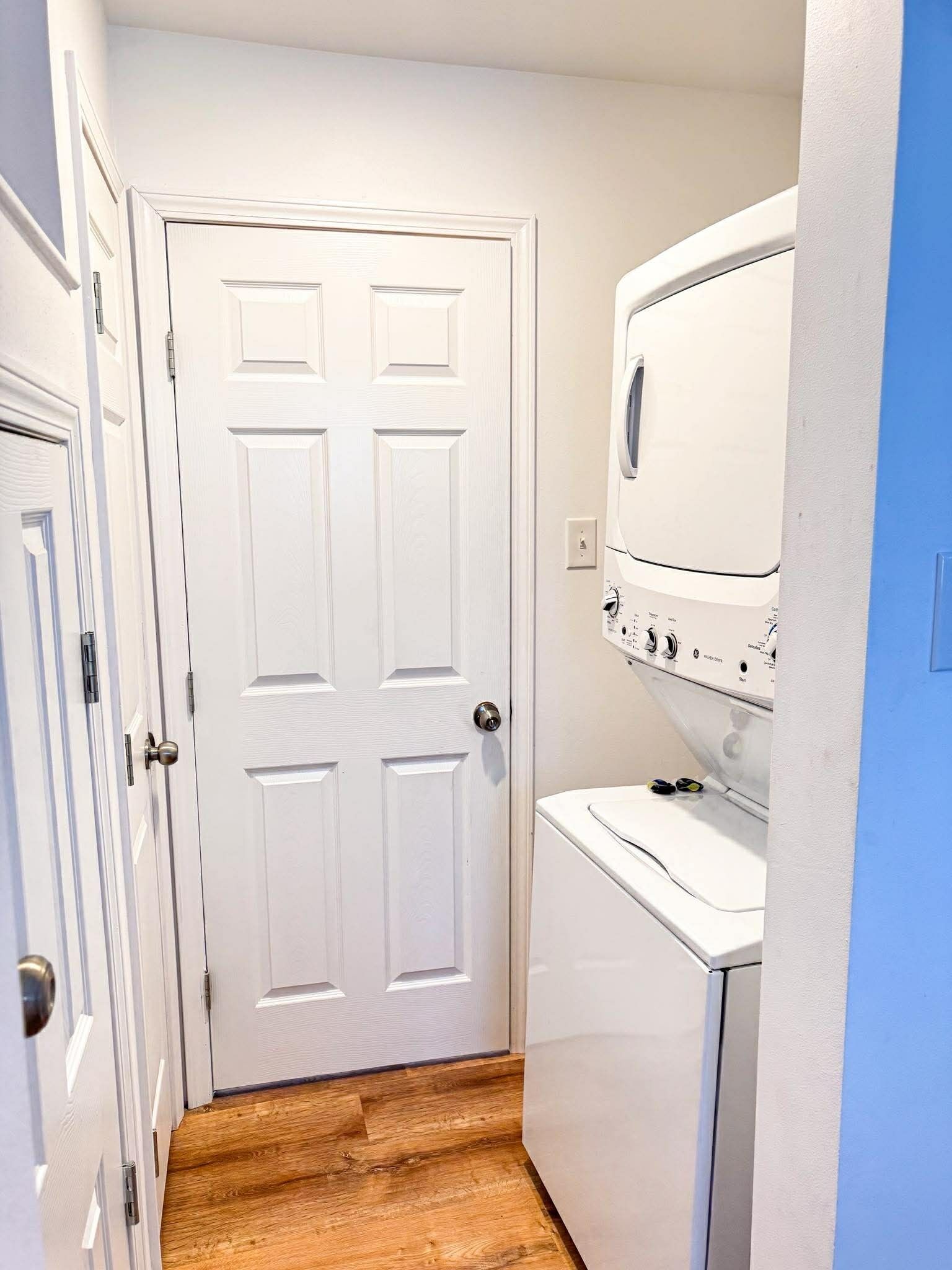 A laundry room with a white door, a washing machine, and a dryer.