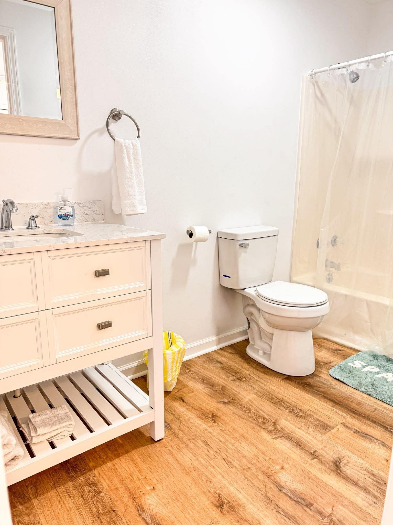 A bathroom with a toilet, sink, and shower curtain.