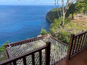 A wooden deck with a rope barrier overlooking a coastal view. - Suwehan Beach Cliff House  (Penida Island)