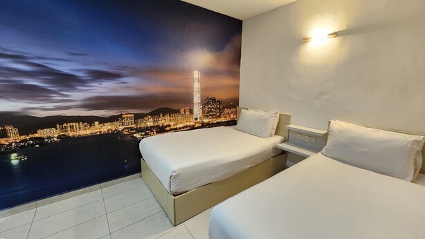 Quarto de hotel com duas camas, um mural com vista para a cidade e vista noturna da cidade.