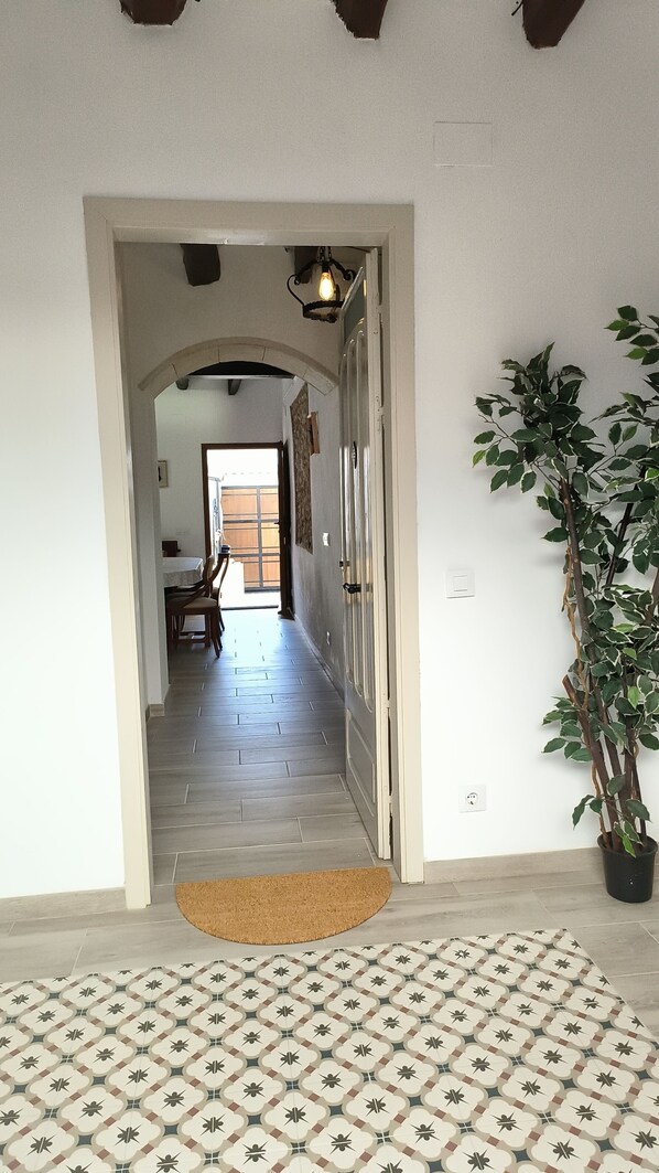 Stunning hallway leads to a dining area with a table and chairs.
