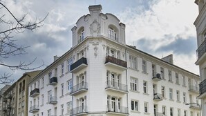 A multi-story building with a classic architectural style, featuring balconies and large windows.