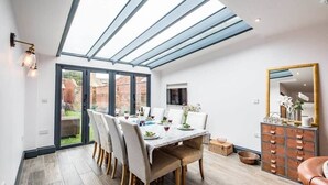 Un coin repas avec une table dressée pour quatre personnes, un miroir et un meuble en bois doté de tiroirs.