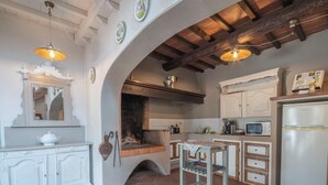 A kitchen with a fireplace, white cabinetry, and a microwave. - Wonderful private villa with A/C, private pool, WIFI, TV, pets allowed and panoramic view (Cantagrillo-casalguidi)