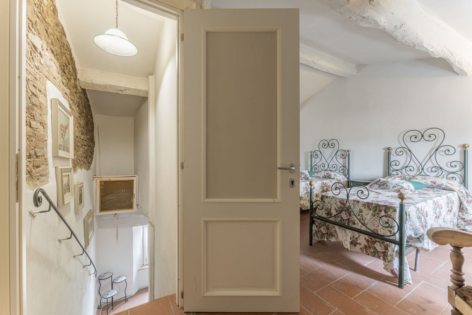 Une chambre à coucher avec un lit, une petite table et une porte.