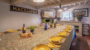 A long dining table with yellow plates and wine glasses, a fireplace, and a sign reading 'MACELLERIA'. - Wonderful private villa with A/C, private pool, WIFI, TV, pets allowed and panoramic view (Cantagrillo-casalguidi)