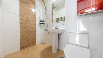 Baño con ducha, inodoro y lavamanos.