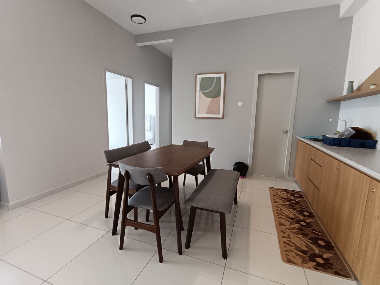 Una cocina moderna con encimera de madera, una mesa de comedor con sillas y una alfombra estampada.