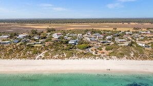 Luftaufnahme eines Küstenwohngebiets mit Häusern, Straßen und einem Strand.