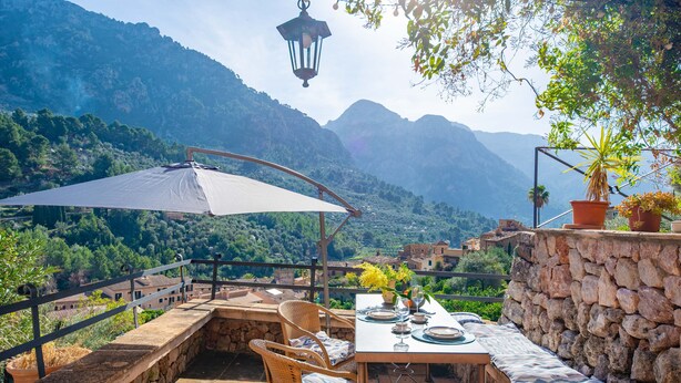 An outdoor dining area with a table set for two, surrounded by stone walls and a view of mountains. - SA TEULERA (FORNALUTX) - Fabulous house with stunning views of the Serra de Tramuntana - F (Fornalutx)